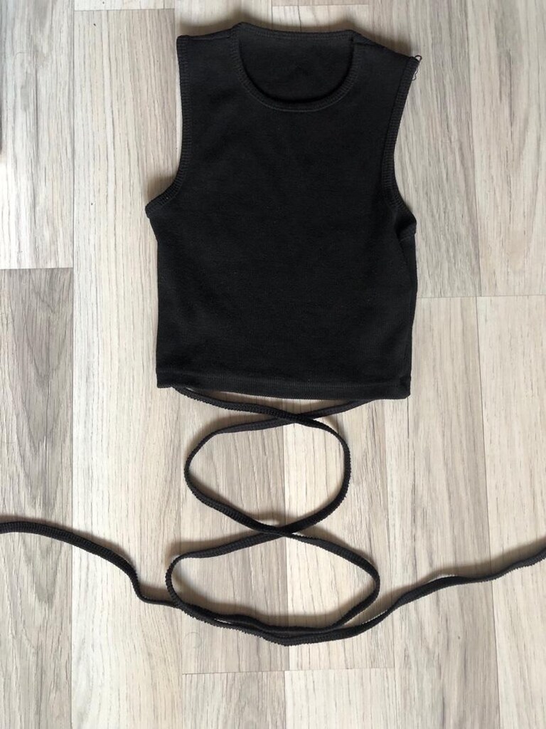 Siyah, yüksek yakalı, bel detaylı ve ince askılı crop top. Düz, sentet