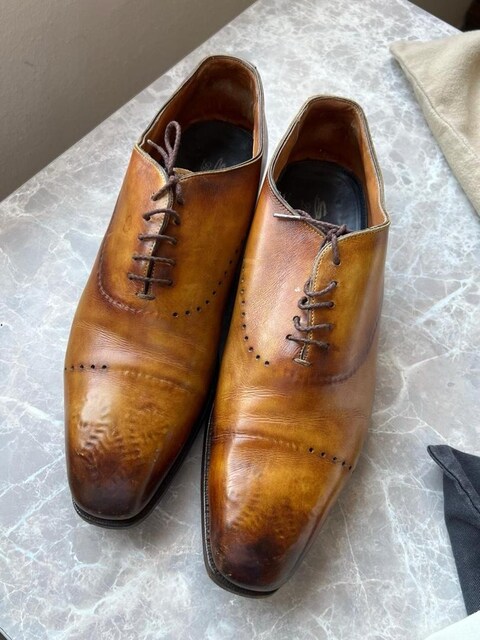 Santoni markasına ait kahverengi deri bağcıklı ayakkabılardır