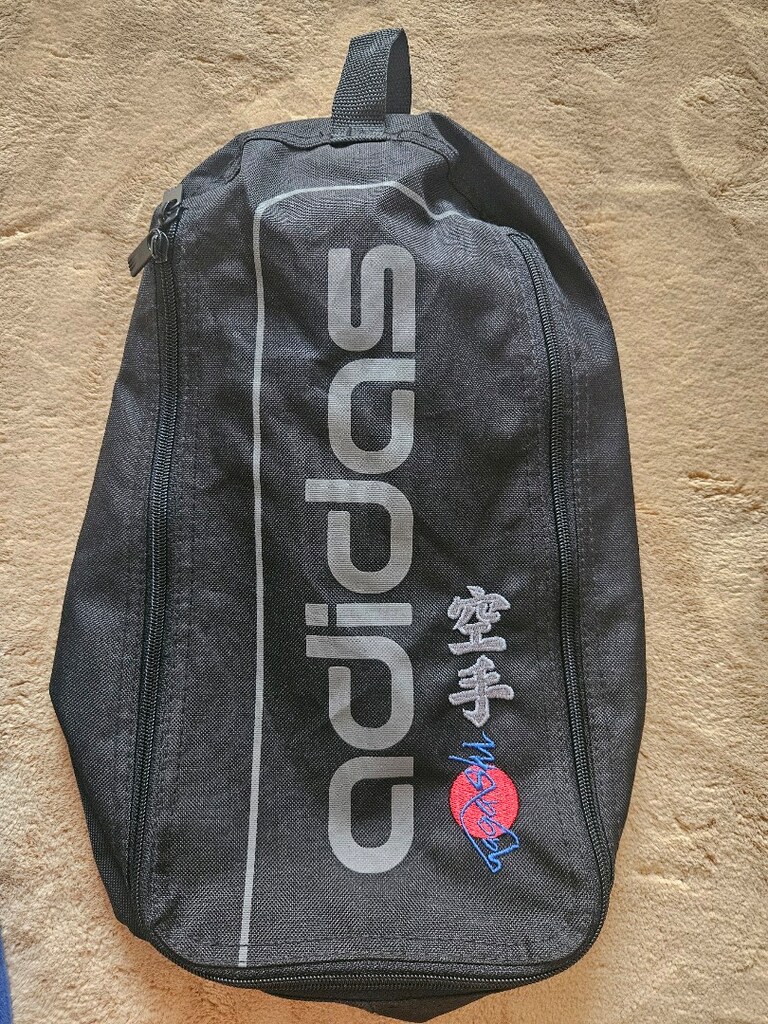 siyah renkli bir adidas spor/krampon çantası (veya eşya çantası)