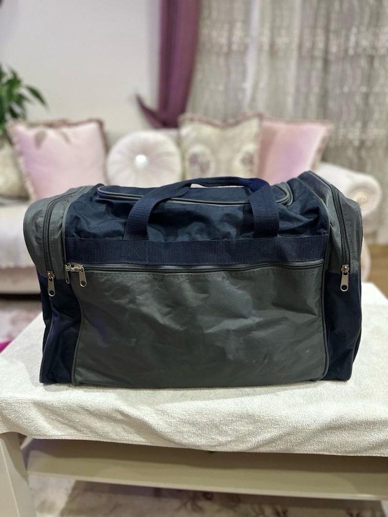 Lacivert ve koyu gri tonlardaki bu seyahat çantası, fermuarlı geniş an