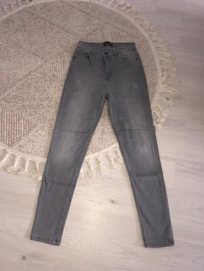 Klasik kesim, yırtık detaylara sahip gri renkte jeans pantolon. Günlük