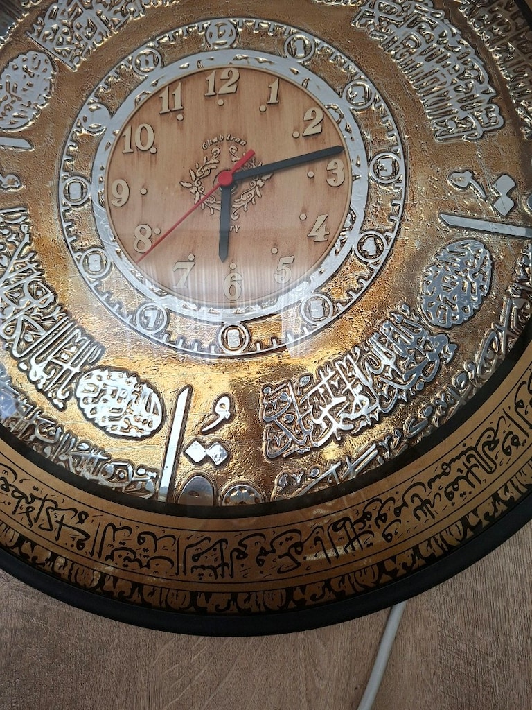 İslami yazılarla süslenmiş yuvarlak duvar saati