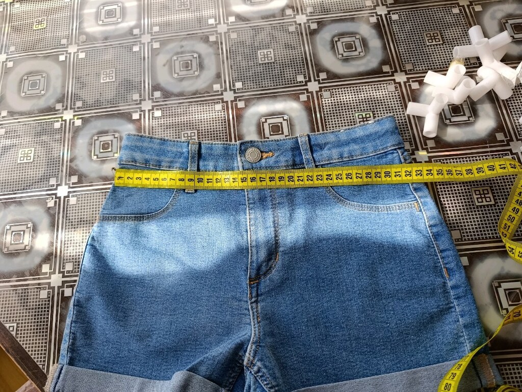Mavi denim şort, hafif yıkamalı görünümü ve klasik beş cepli yapısıyla